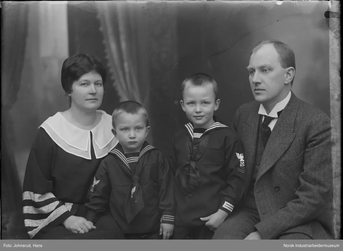 Familien Coward, kvinne og mann med to gutter fotografert i studio.