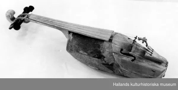 Träskofiol, handgjord, med tillhörande stråke. Längd (fiol) 52 cm.
