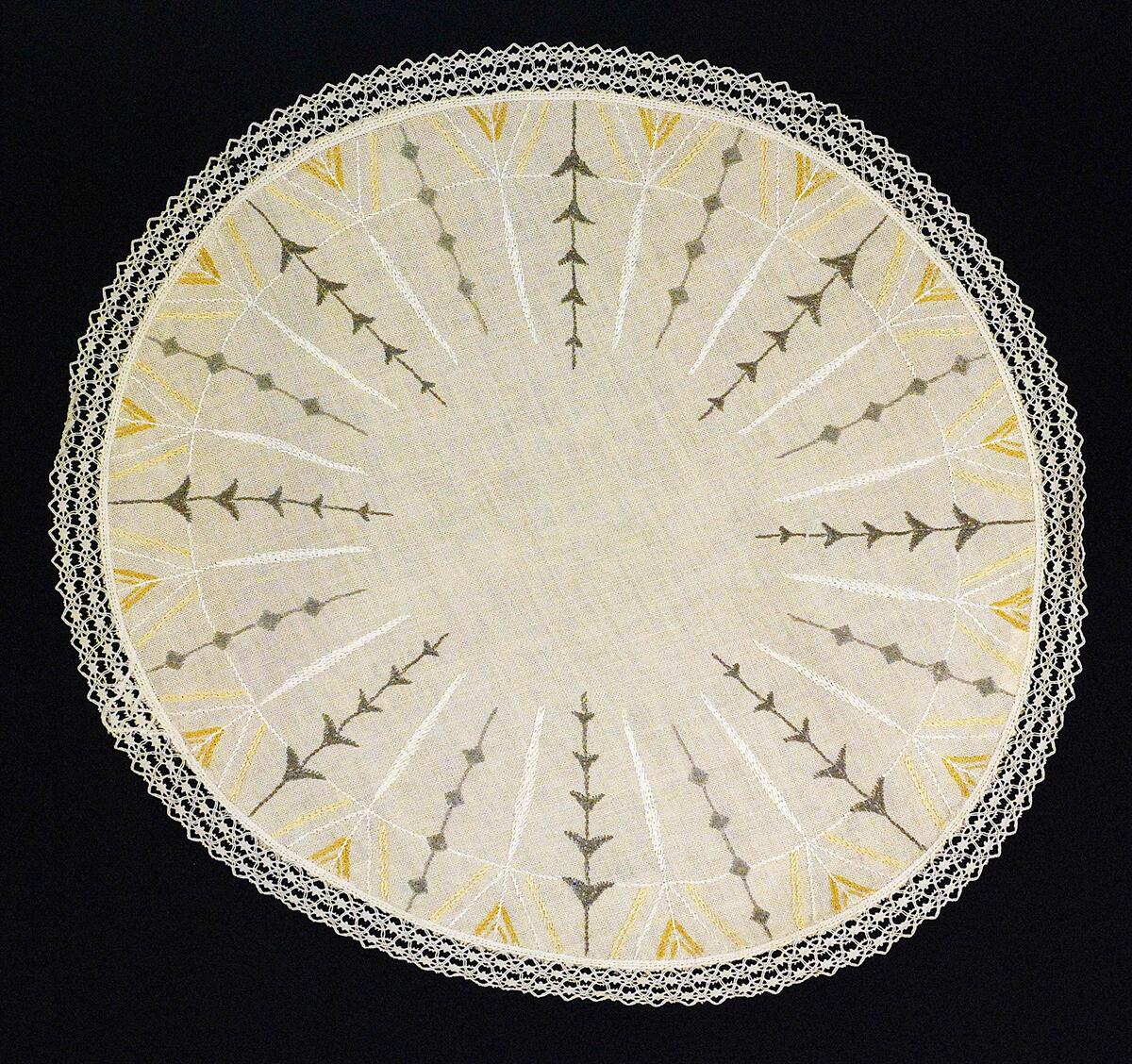 Rund grå-beige duk av "räknelinne" med broderat mönster i grått, vitt och beige. Spetskantad
Nyreg 010827 TL