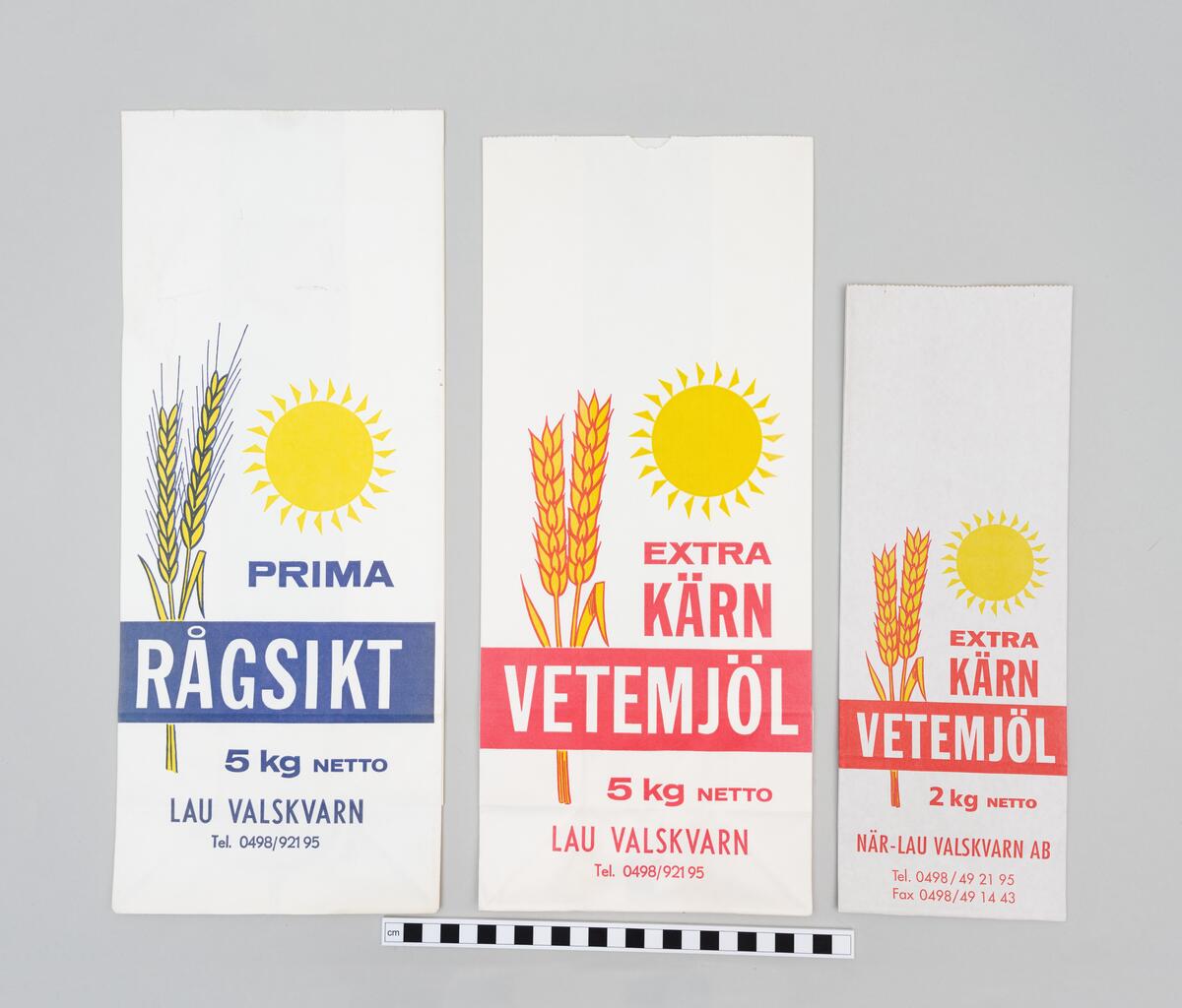 Oanvända förpackningar och säckar i papp för dinkel- och vetemjöl, mannagryn och groddar från När-Laus Valskvarn AB. 
 
Åtta förpackningar för produkter av dinkel; 
Helkorn 1,2 kg. Beige påse, tryckt. Blank yta. 
Mannagryn 1 kg. Grå påse, tryckt. 
Mjöl 1 kg. Beige påse, tryckt. Matt yta.
Groddar med kli från dinkel, 500 g. Vit påse, vit etikett. 
Skiktat Fullkorn, 2 kg. Vit påse, vit etikett. 
Kross, 5 kg. Vit påse, vit etikett. 
Fullkorn, 5 kg. Vit påse, vit etikett. 
Fullkorn, 5 kg. Brun påse, vit etikett. 

Tre tryckta förpackningar illustrerade med ax; 
Extra Kärn Vetemjöl, 2 kg. Vit påse, design och text i rött och gult.
Extra Kärn Vetemjöl, 5 kg netto. Vit påse, design och text i rött och gult.
Prima Rågskikt 5 kg netto. Vit påse, design och text i blått och gult.

En större pappersförpackning; Extra Kärnvetemjöl, 3 * 5 kg. Brun påse, röd text. 

En mindre säck; Vetemjöl, 25 kg. Vit säck, röd text. Illustrerad med bård av stiliserade veteax.  

Två större säckar för utsäde; 
Fälkontrollerat Utsäde. Vit säck, gul text. Gula bårder längs med långsidorna på säckens framsida. 
Hemodlat Utsäde Från Bygdekvarnen, Betat. Brun säck, svart text. Rutor med svart bård, gul bakgrund och svart text.