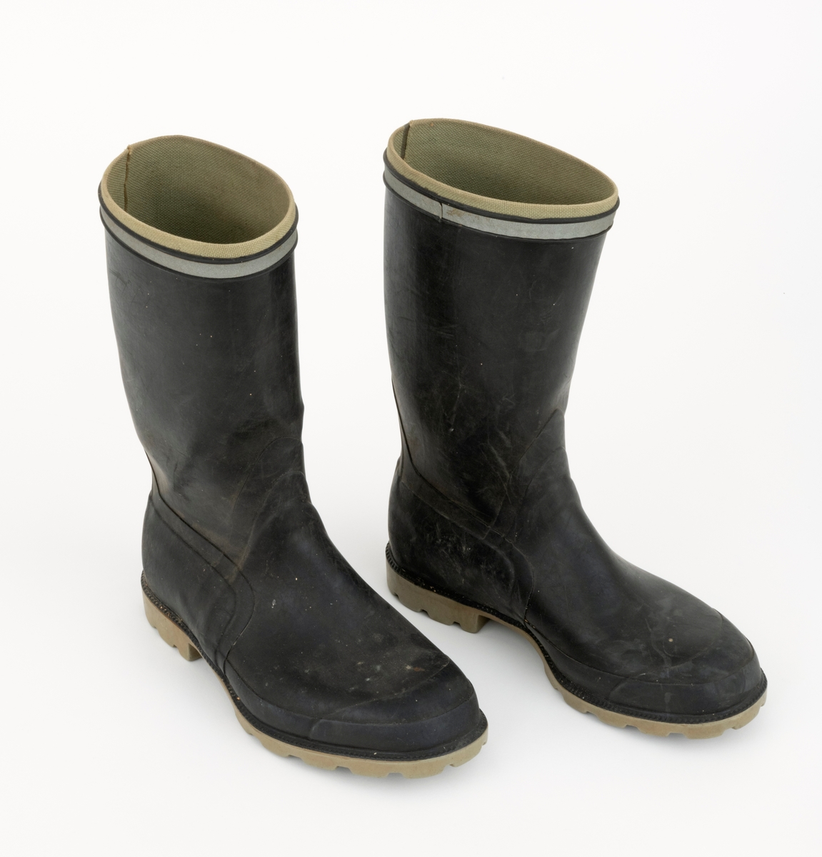 Gummistøvler eller langstøvler - vanntett fottøy med høye skaft - brukt under vandring på vått underlag utendør, sannsynligvis også i fjøs, der det var møkk på golvene. Dette støvleparet ble antakelig brukt av småbrukeren Iver Eide (1886-1976) fra Tolga på hans eldre dager. Støvlene har grålige såler med markerte hæler, og med 4,5 - 5,5 millimeter djupt riflemønster, som antakelig skulle forebygge at den som gikk med støvlene skled på glatt underlag. Ellers er støvlenes ytterflater lagd av mørkebrun, nesten svart gummi, som er noe tjukkere og mer solid langs sålene og mot hælene enn over vristpartiene og i skaftene. Rundt skaftenes overender er det pålimt cirka 1 centimeter brede refleksband. Innvendig er gummien trukket med et finmasket striestoff. Støvlene har innlagte såler av et tynt pappmateriale. Produsentens logo - en slags borg med tre tårn og firmnavnet «TRETORN», samt «MADE IN SWEDEN» og størrelsesbetegnelsen «40» - innstøpt på undersidene av sålene. Støvlebrukeren har tråkket en liten jernstrift inn i den høyre såla.