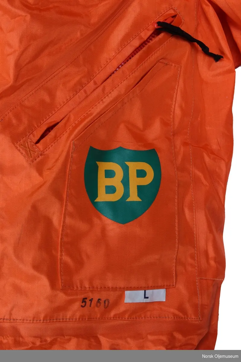Redningsdrakt med BP sin logo foran på brystlomme. Drakten er utstyrt med munnstykke til oppblåsing av innvendig pute.