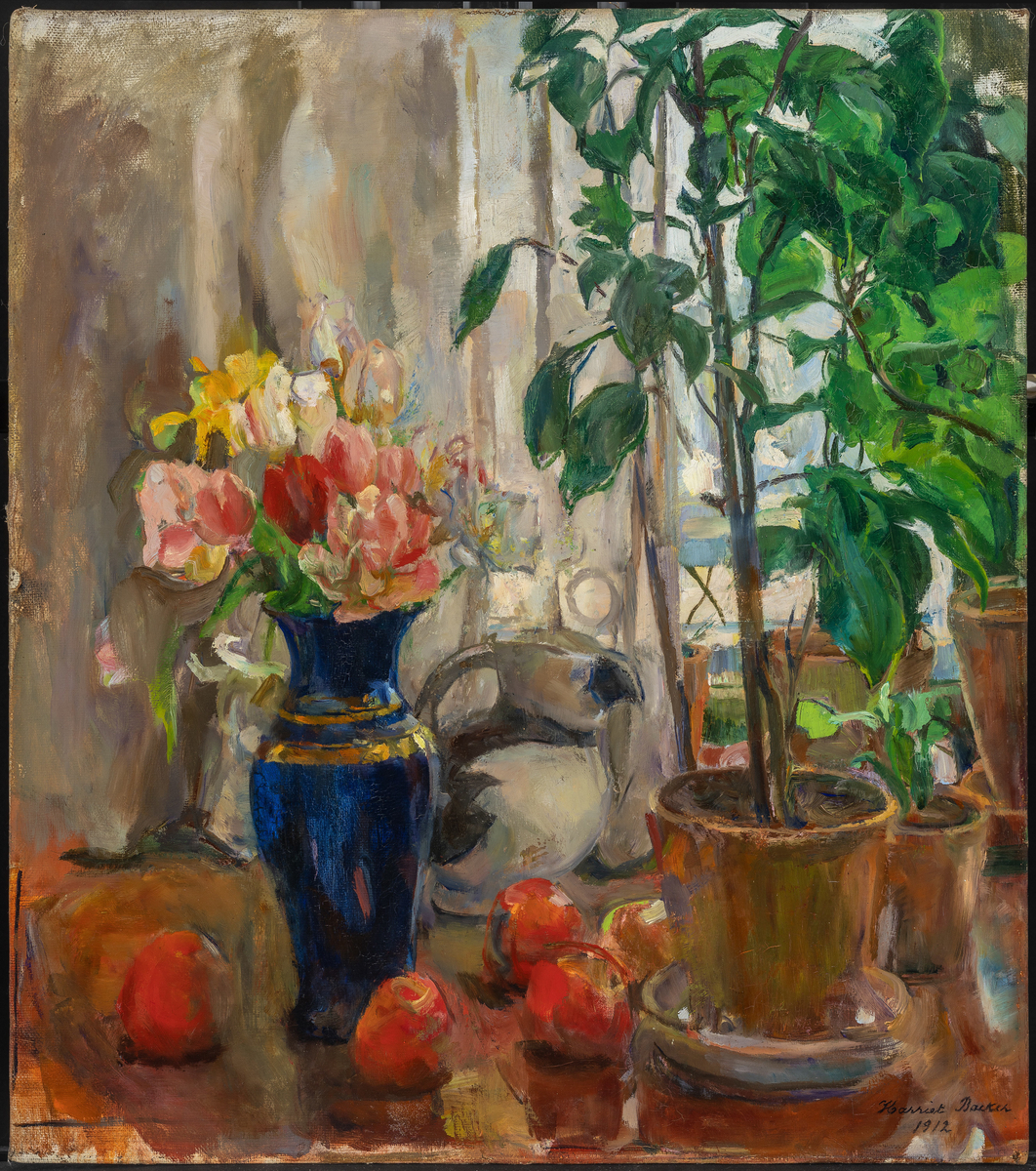 Bord med potteplante, alkemugge, røde epler og blå vase med blomster.