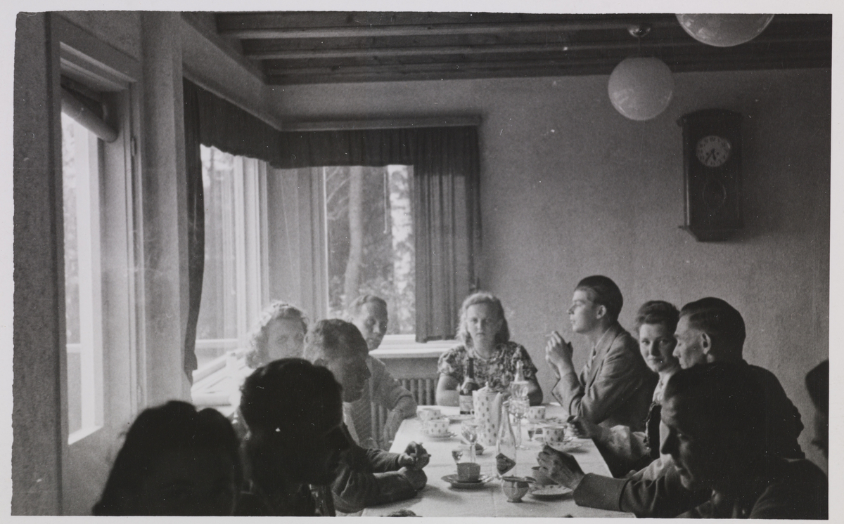 Menn og kvinner samlet til te eller kaffeselskap. Lengst bak i bildet til venstre kan man se Zeidler og  fremst til høyre, Kuntze (?)