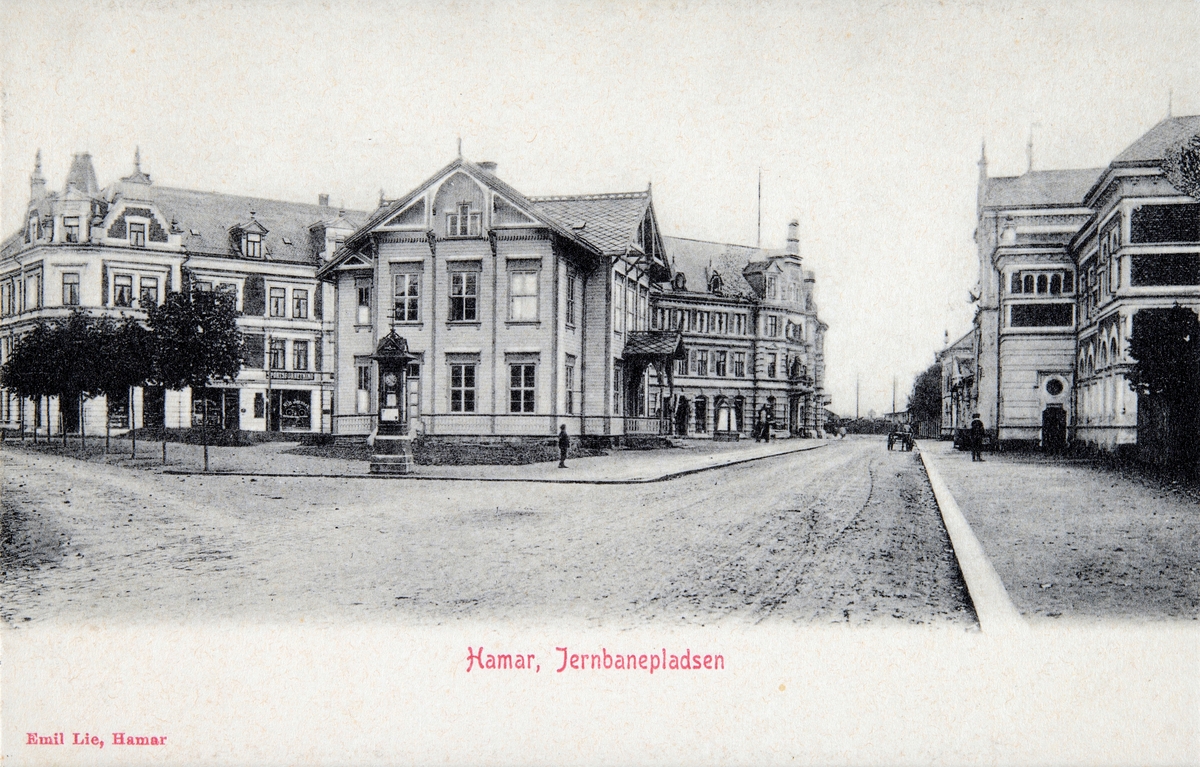 Postkort, Hamar, Jernbaneplassen med Hamars første stasjonsbygning, bygården Torggata 3, Grand Hotell, Hamar stasjon,