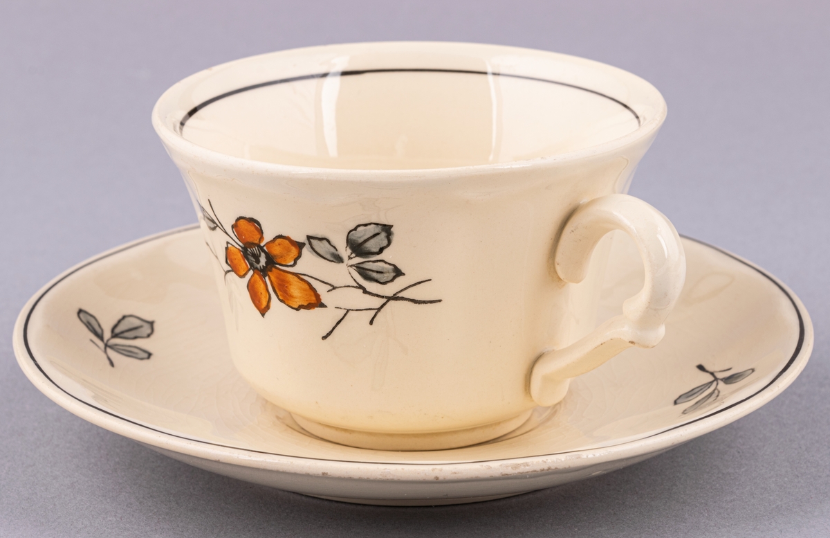 Kaffekopp med fat, i flintgods. Modell AK, dekor Bibo. Vit glasyr med flerfärgat blommönster. Skapad av Eugen Trost för Gefle Porslinsfabrik 1936.