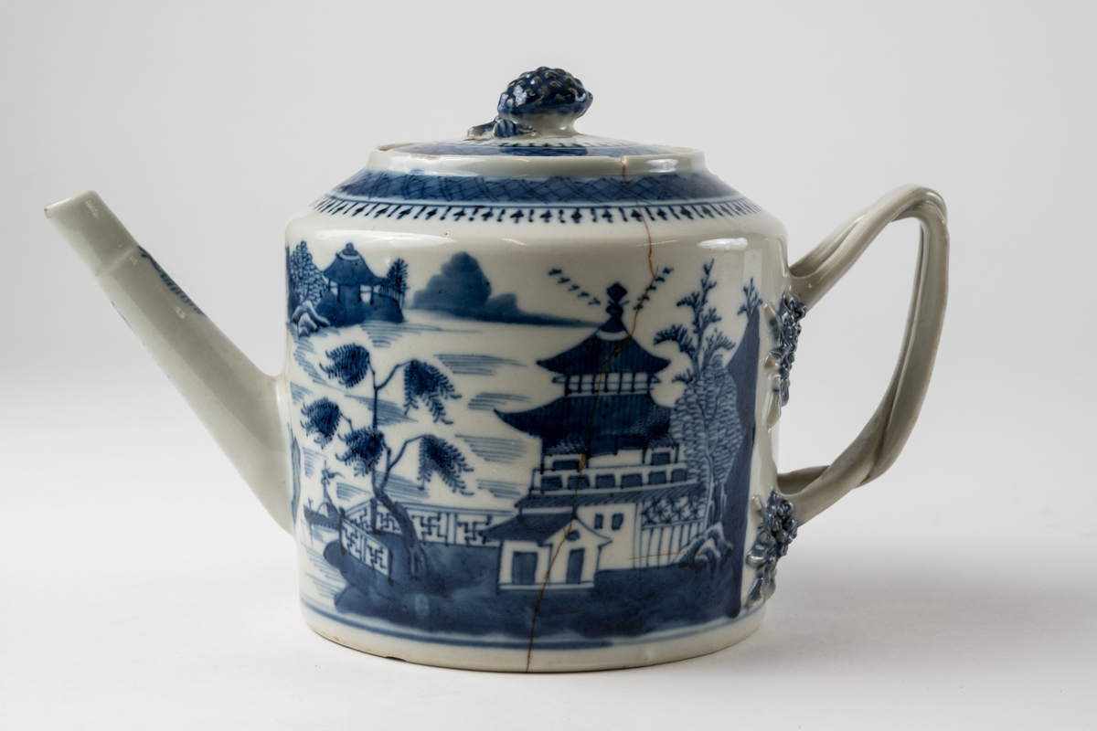 Tekanna i blåvitt så kallat ostindiskt eller kompaniporslin. Traditionell landskapsdekor med pagoder, sjö med båt med mera. Tvådelat, tvinnat handtag.

Enligt uppgift från Linn Bennich (Bukowskis, 13 feb 2023) Qianlong (ca 1736-95) eller Jiaqing (1796-1820), tillverkad i Kina för den europeiska marknaden. Underglasyrblå dekor med motiv av flodlandskap, tål maskindisk.