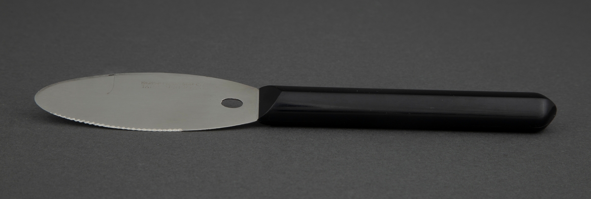 Smørkniv i rustfritt stål med svart, kantete nylonskaft. Skaftet er festet rett til bladet. Utstanset oval nederst i knivbladet for oppheng.