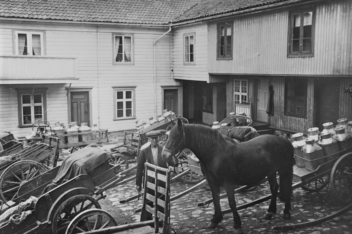 Oppland, Lillehammer, bakgården til Thorstad gården i Storgata med hest, kjerre med melkespann og kjørekaren Mathias Iversen