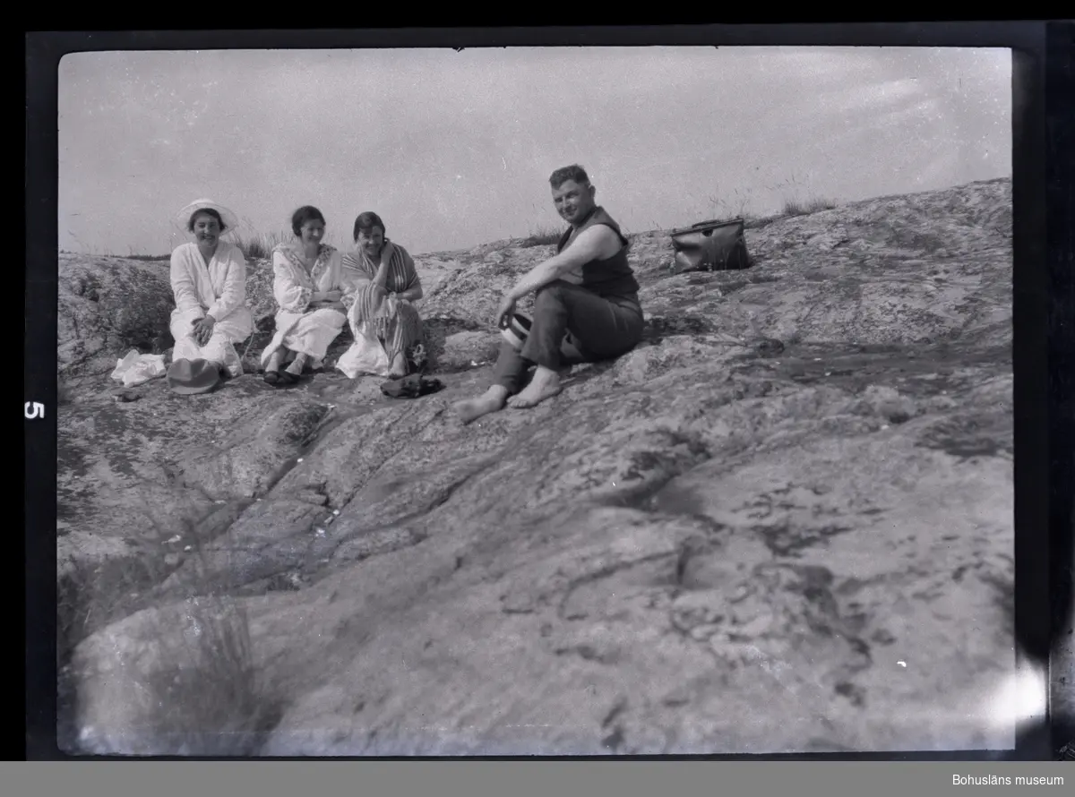 Fyra personer sittandes på en klippa.
