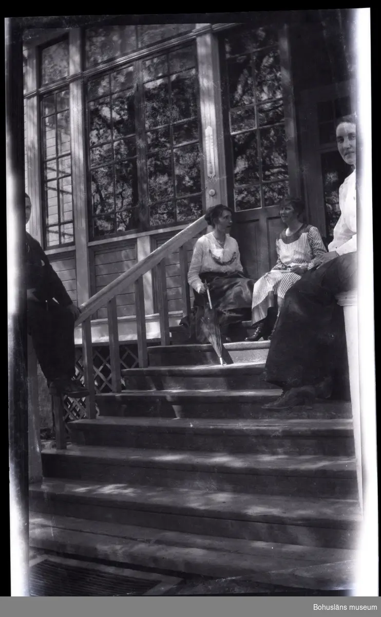 Fyra personer sittandes på en trappa framför ett hus.