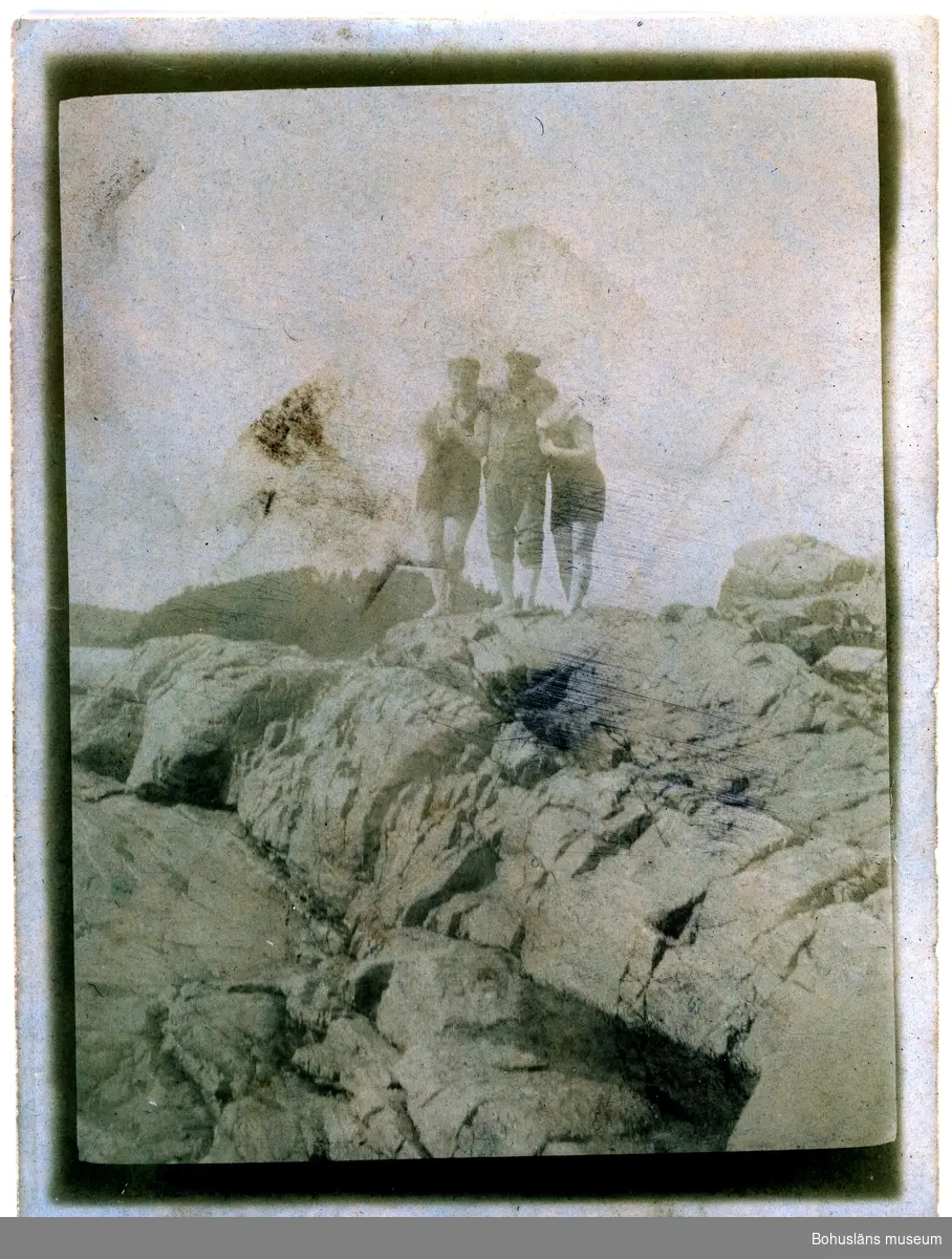 Tre personer på en klippa.