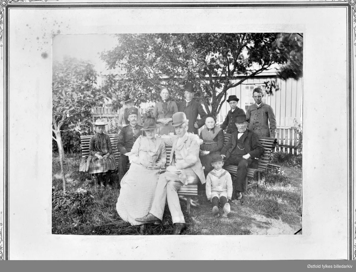 Gruppeportrett av familie i hage. "I bestemors hjem i Sarpsborg". Mor og onkel Karl (bakerst), tante Augusta (til høyre) , major Andresen (til høyre), Aagot, Rolf Sigurd, bestefar og bestemor, Carsten. tante Fanny og onkel Kristian foran som nygifte 1890.