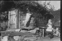 To barn stående på utsiden av en laftet hytte "Hygga" i Gvep
