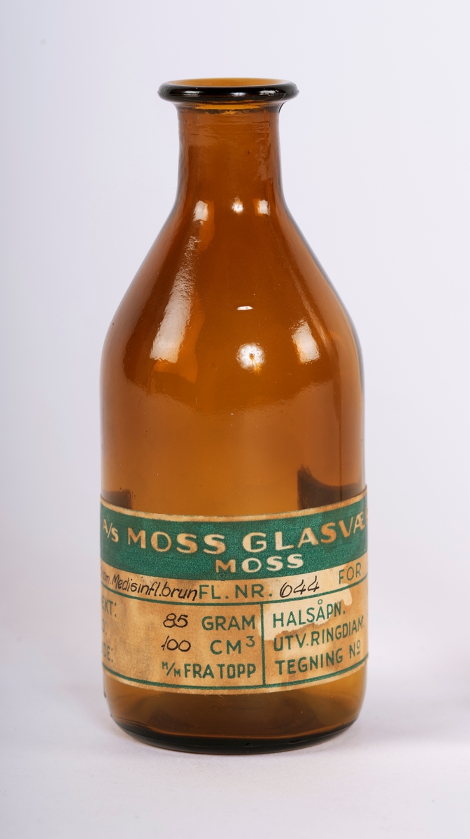 To sylindriske medisinflasker fra Moss Glasværk - en i klart og en i brunt glass.