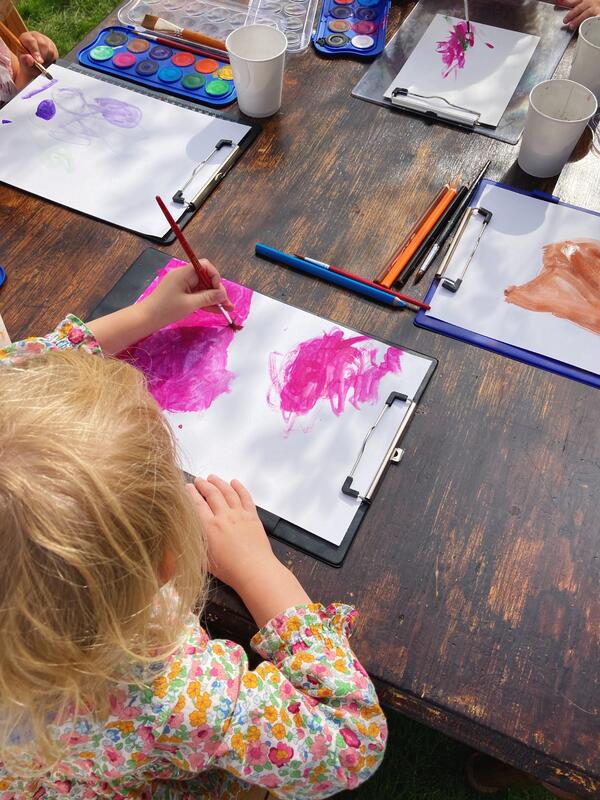 Ei jente maler et bilde under Barnas dag 2022.