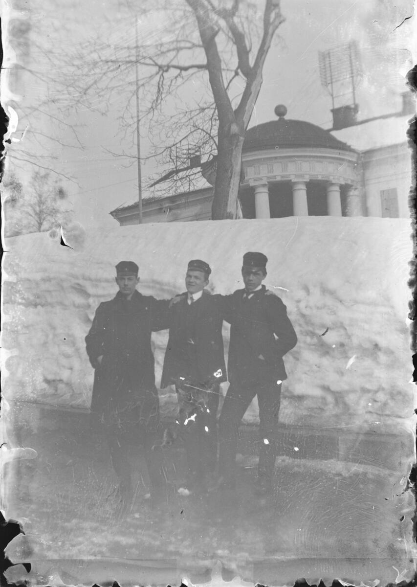 "J. L., Wedin, Allard. Fotograf V. Karlsson." Tre män framför Härnösands rådhus, på vintern.