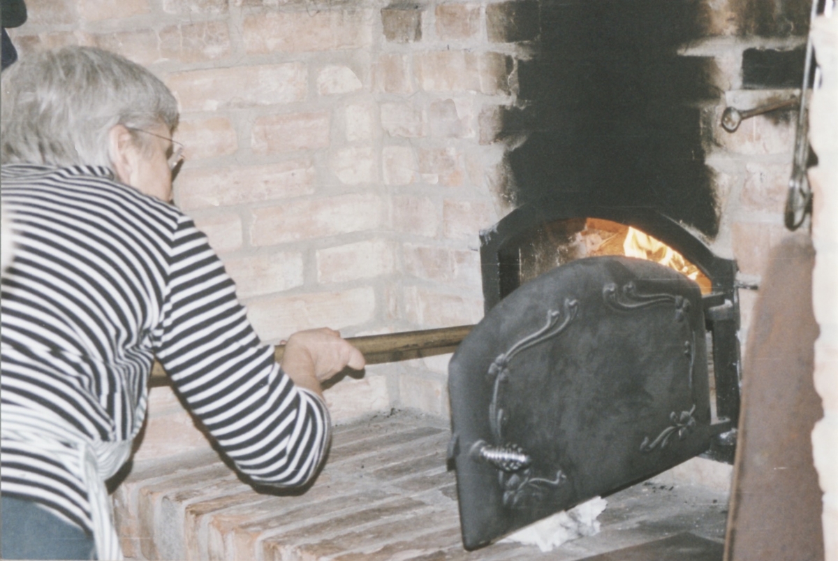 Kållereds Missionsförsamling har brödbakningskurs i Vallda bakstuga 1970-tal. Ulla Öqvist för in brödspateln i ugnen.