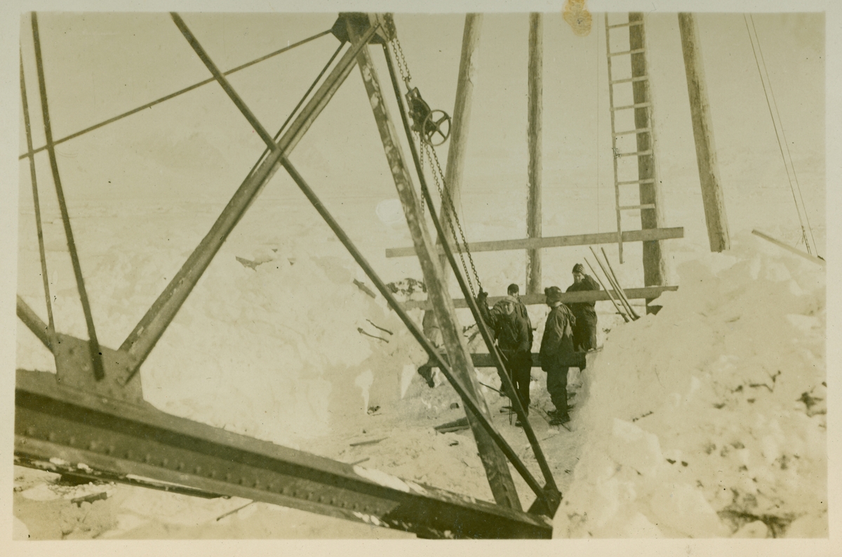 Bygge av en luftskipmast midt ute på isbreen. Masten har 35 meter høy og veier 1.4 tonn). Norge's Polflyvning 1926 fra Norsk Luftselladsforening. Gjenstandsnummer SVB 1837