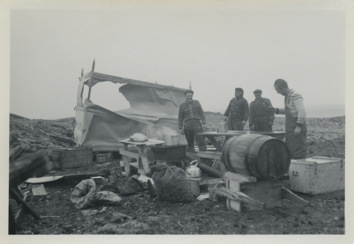 Tre menn lager mat. Feltarbeid.Bildet kommer fra Øystein F. Klingenbergs samling. Han var ingeniør tilkalt til Svalbard til å ordne noe med radar og kullbåtene.