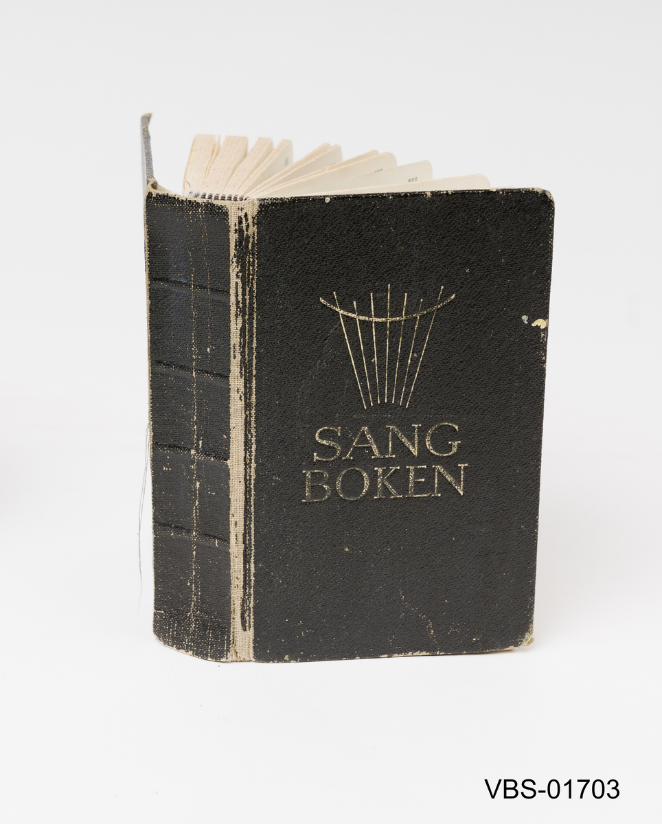 Ved navnet på boken som er trykket på forsiden SANG BOKEN, er det også trykket et motiv (et musikk/sang-tegn) I permene er det dekorert med små gull-kors.