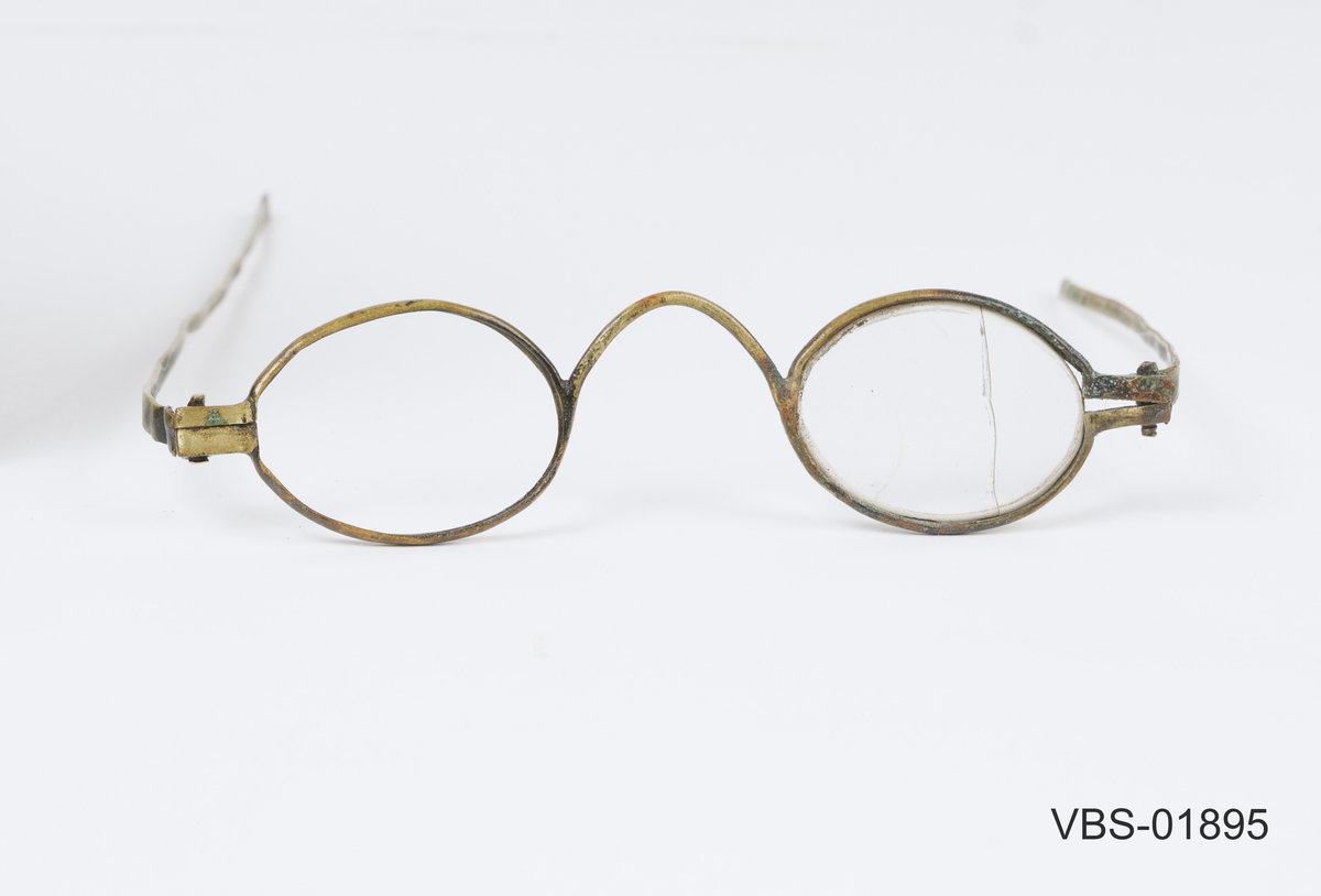 Leddet innfatning med to stenger som kan brettes sammen/ strekkes ut. Tilnærmet smal, oval utformet front med tilpasset brilleglass.
Eliptiske glass.