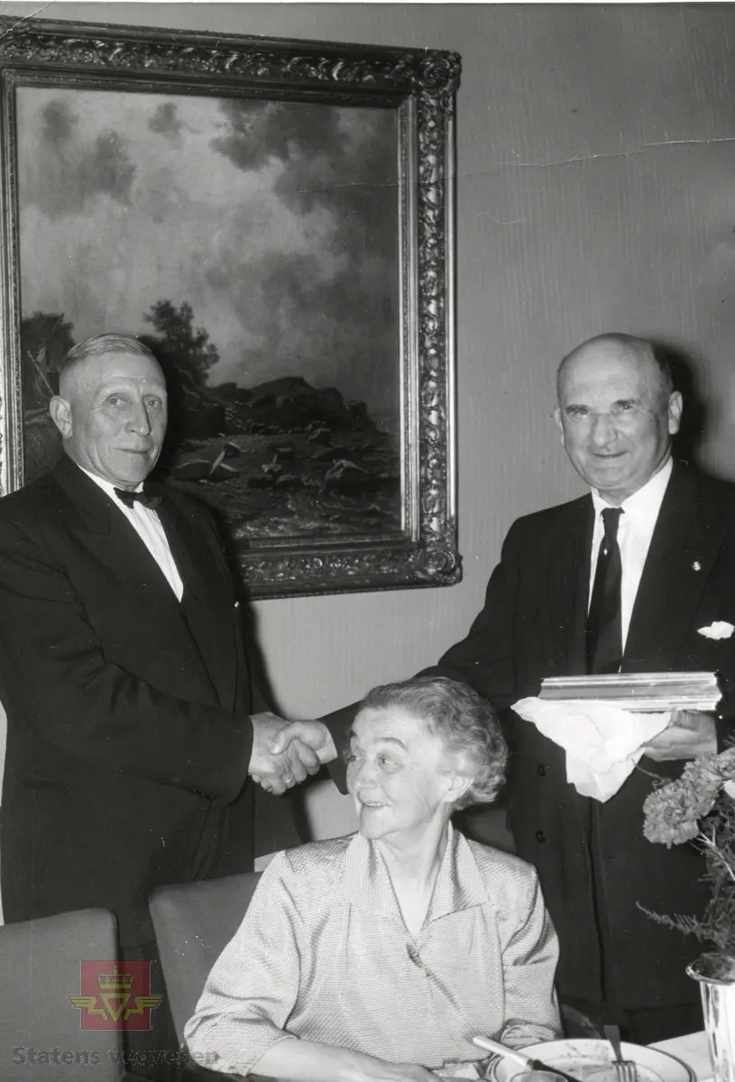 Gaveoverrekkelse til vegsjef Olav Ødegård ved  hans fratredelse  i 1956. 
Fra venstre: Lars Lillehammer, fru Ødegård og Olav Ødegård.
