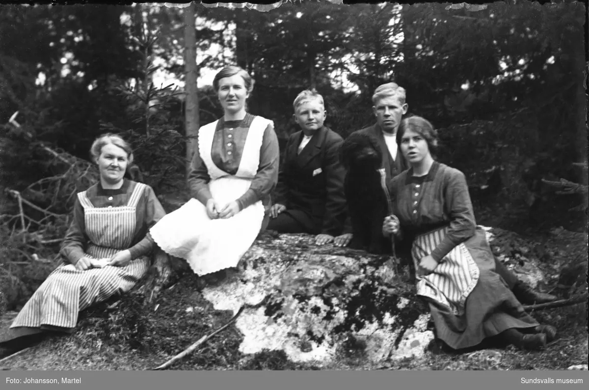 Gruppbild utomhus med syskonen Sigrid Persson, Märta Johansson, Gustaf Persson och Johanna "Hanna" Johansson samt en hund. Den yngre pojken i mitten är oidentifierad.