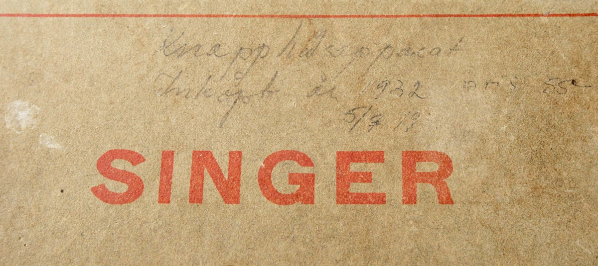 Rakt, platt knivblad med vass egg. Svarvat handtag med knopp i brunbetsat trä. Medföljer ett mindre avlångt knivblad. Förvaras i brungrå papplåda med röd text: "SINGER". Slitage. Ovanför texten skrivet med blyertspenna: "Knapphålsapparat. Inköpt år 1932. Pris 55 kr. 5/7 1932".

Funktion: Att tränsa knapphål på vanlig symaskin (smal och kort zig-zagsöm)