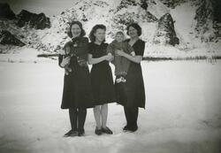 Tre kvinner, et barn og en hund fotografert på Steigberget p