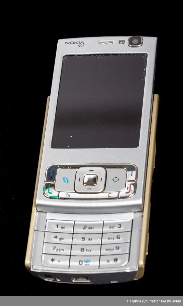 Nokia N95 (Tillverkare: Nokia, modell: N95) med yttre skal av hårdplast i grå- och guldmetallic.

På telefonens framsida en digital skärm, kameraoptik, en knappsats, samt märkningen: "Nokia n95". Hela framsidan är en skjutlucka som ger åtkomst till en knappsats undertill. På telefonens sidor finns en rad knappar, uttag samt en lucka för minneskort (i luckan sitter ett minneskort med kapacitet på 2gb). På telefonens baksida kameraoptik försedd med stängbar lucka samt en avtagbar lucka som döljer batteri och plats för telefonkort (sim). Luckan är märkt "Nokia".
