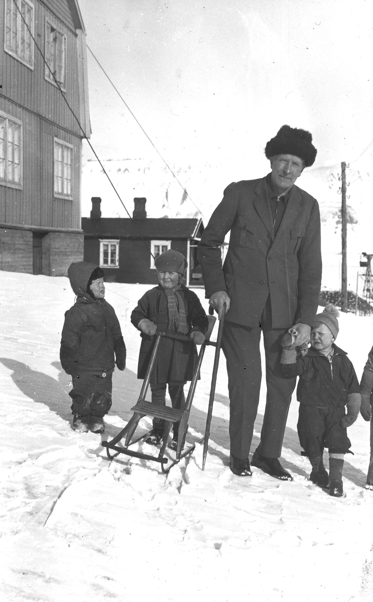 Mann med barn i Longyearbyen. Tekst med bildet: 1. og 2. generation (Stiger Lofthus?)