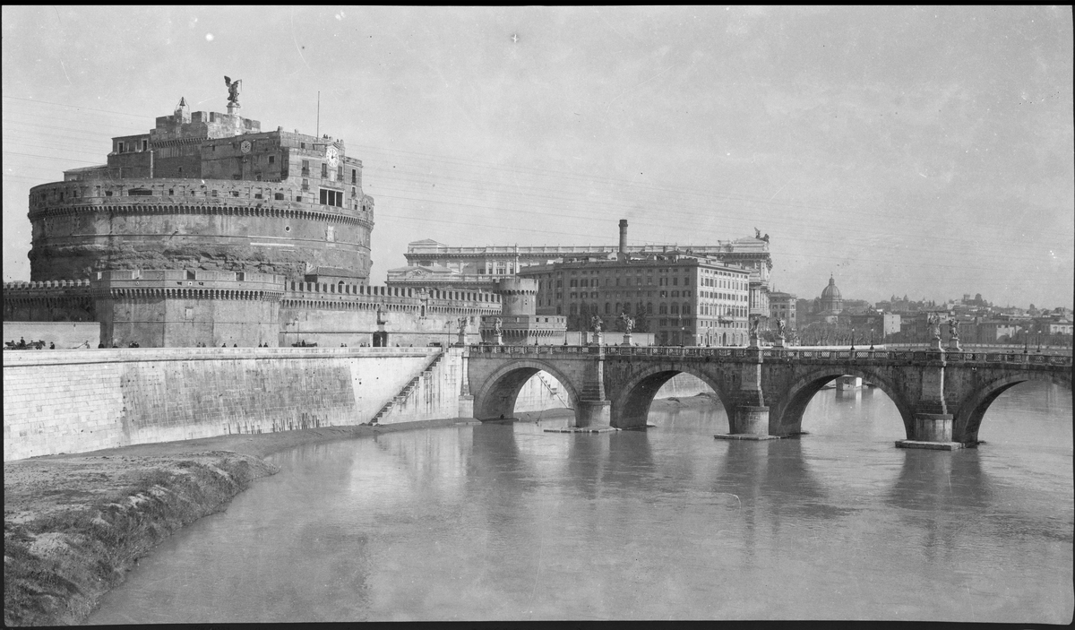 Bymiljø med bro og elv i Roma.