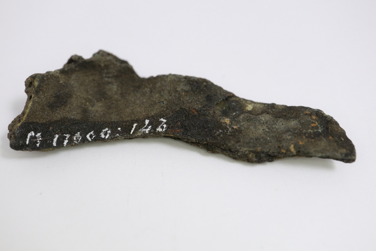 Brandskadat fragment av bronsgryta.  Bukbit.