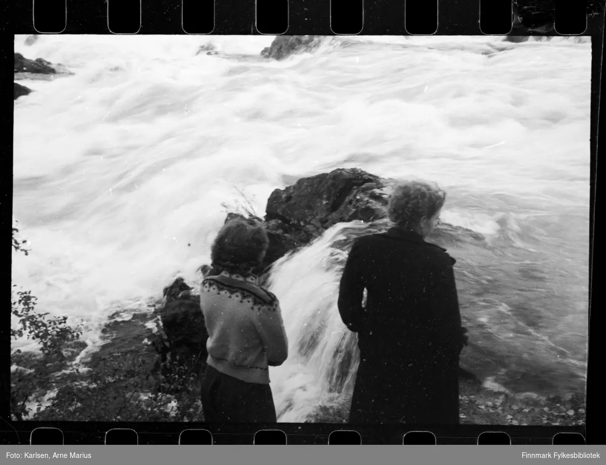 Foto fra Skogfoss i  Pasvikelva. To ukjente kvinner står med ryggen til fotografen

Foto muligens tatt i 1938 (se historikk for referanse)