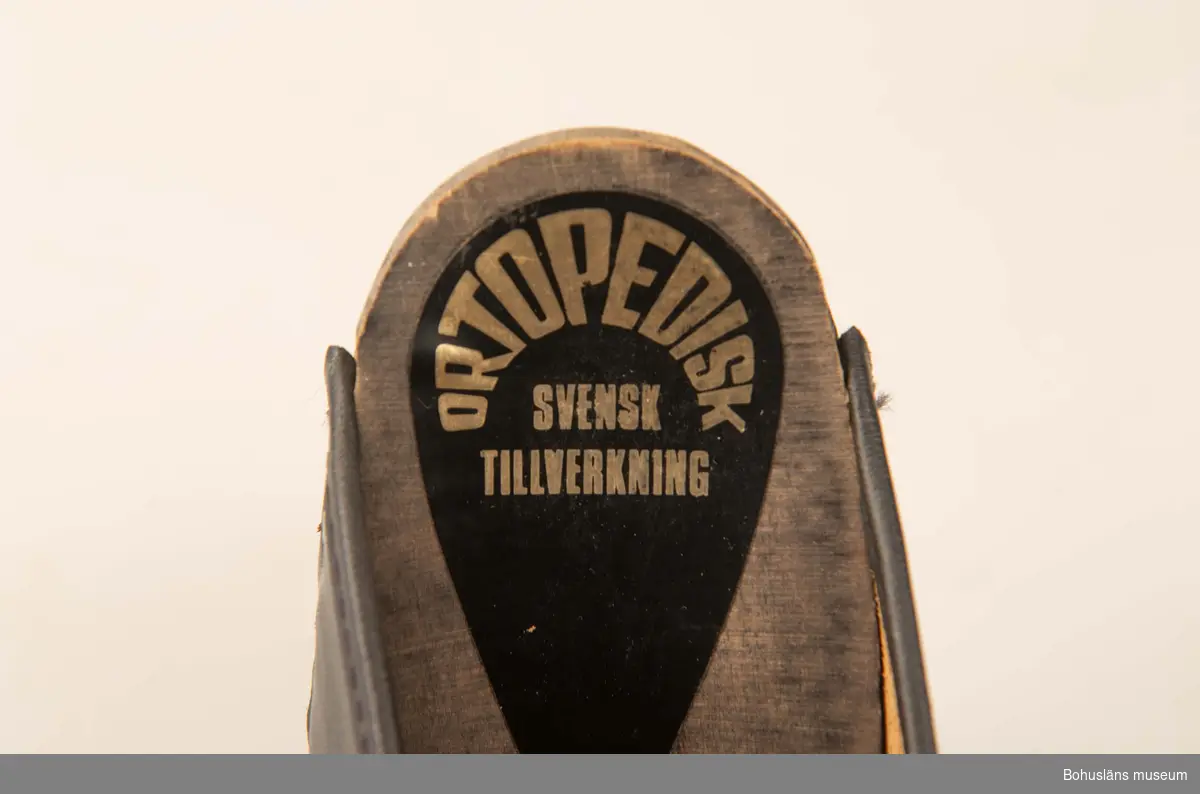 Storlek 39. Ortopediska. Svensk tillverkning. Svartbetsad träsula, svart ovanläder. 
Använda av sillskärerskor vid ABBA konservfabrik i Lysekil.