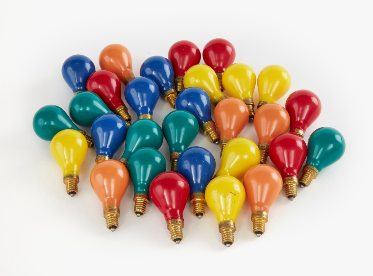 23 glödlampor med tillhörande ask. 6 gula glödlampor, 6 blå, 5 organge och 6 röda. Ask av ofärgad papp.