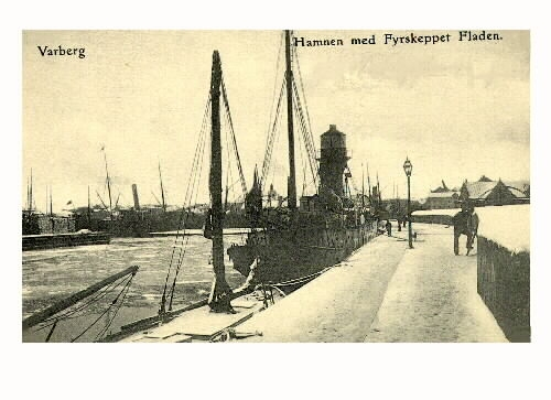 Vykort, "Varberg. Hamnen med Fyrskeppet Fladen" vintertid 1917. Båten ligger vid hamnpirens kaj med varmbadhuset till höger.