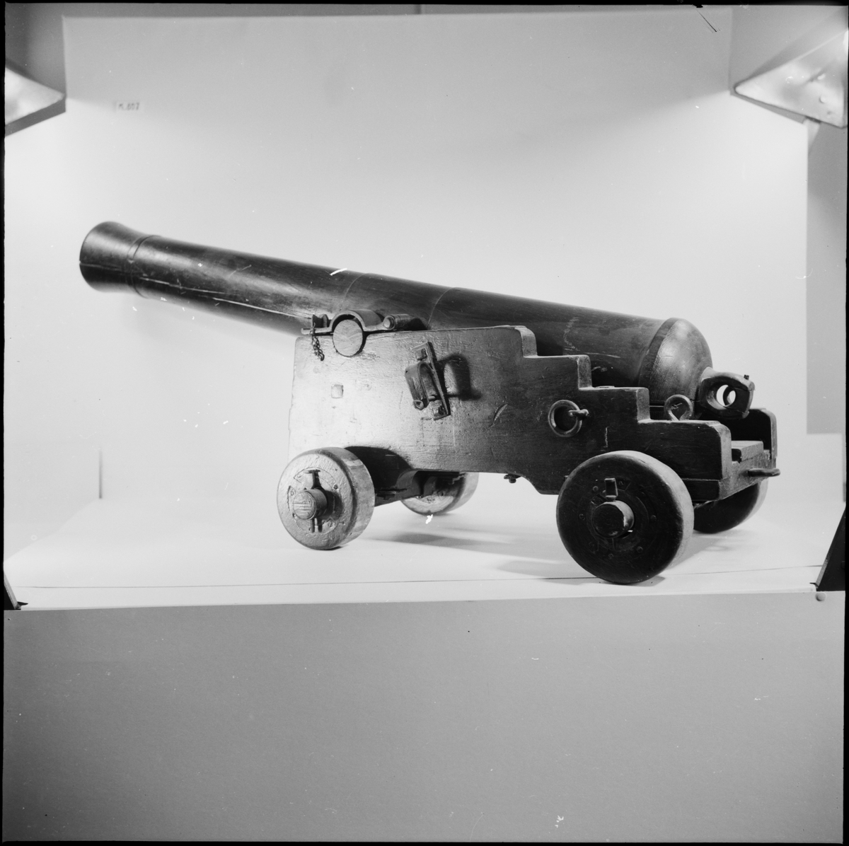 Kanonmodell: 4-rull låda med kanon, av Chapmans modell. Lådan av trä, kanon och beslag av järn. Tillbehör: 1 st ställhult. Lavetten L = 650 mm B = 435 mm H = 315 mm.