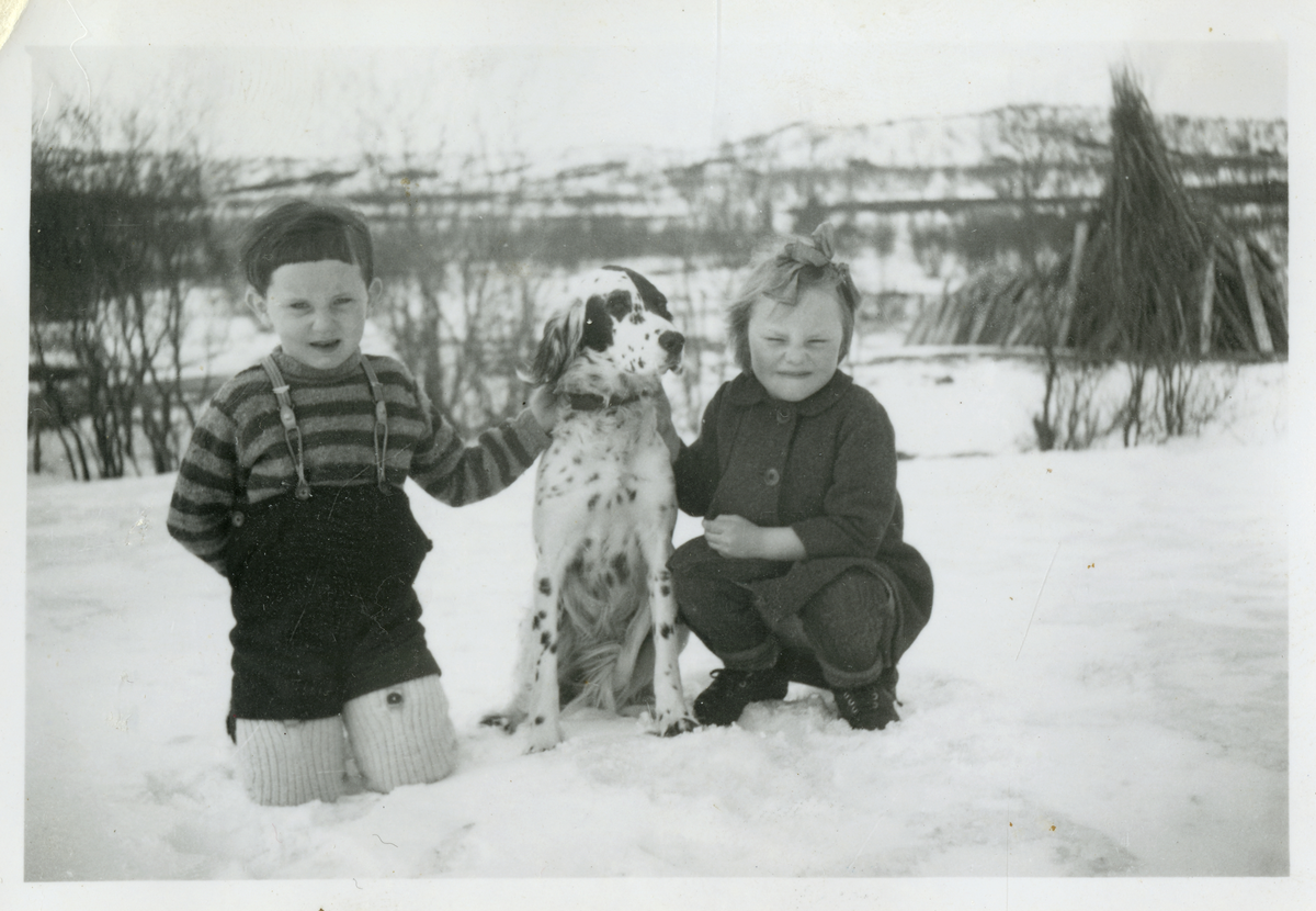 Barn med hund i vinterlandskap.