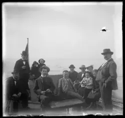 Gruppebilde av personer sittende bakerst i en båt