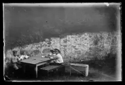 Barn sitter og spiser ved et bord