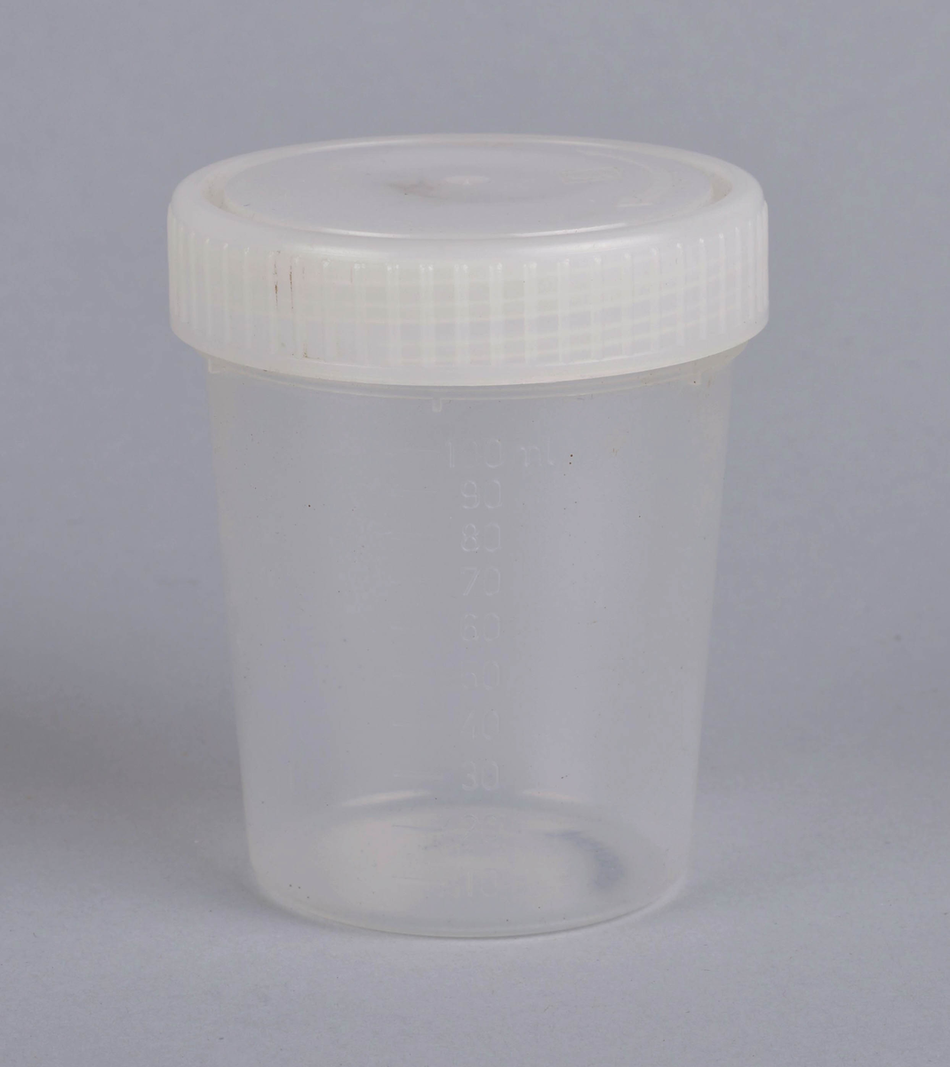Gjennomsiktig plastkopp med måleskala fra 0 - 100 ml.
Hvitt felt for å skrive på verdier eller innhold (2,5 x 4 cm) midt på koppen.
Trolig brukt for oppmåling av væske eller oppbevaring av lignende.