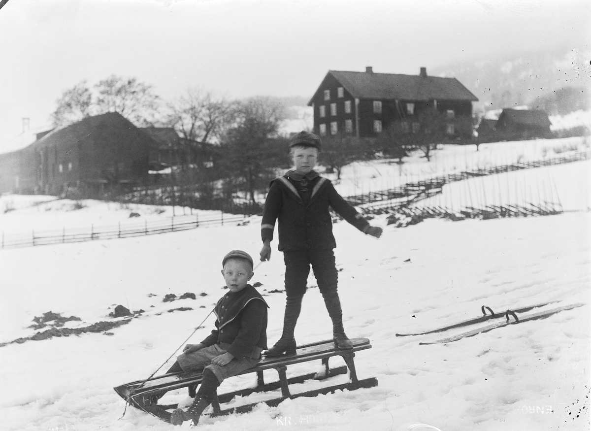 Ringsaker, Ring, Fjølstad østre 369/1, to gutter med kjelke og ski foran gården