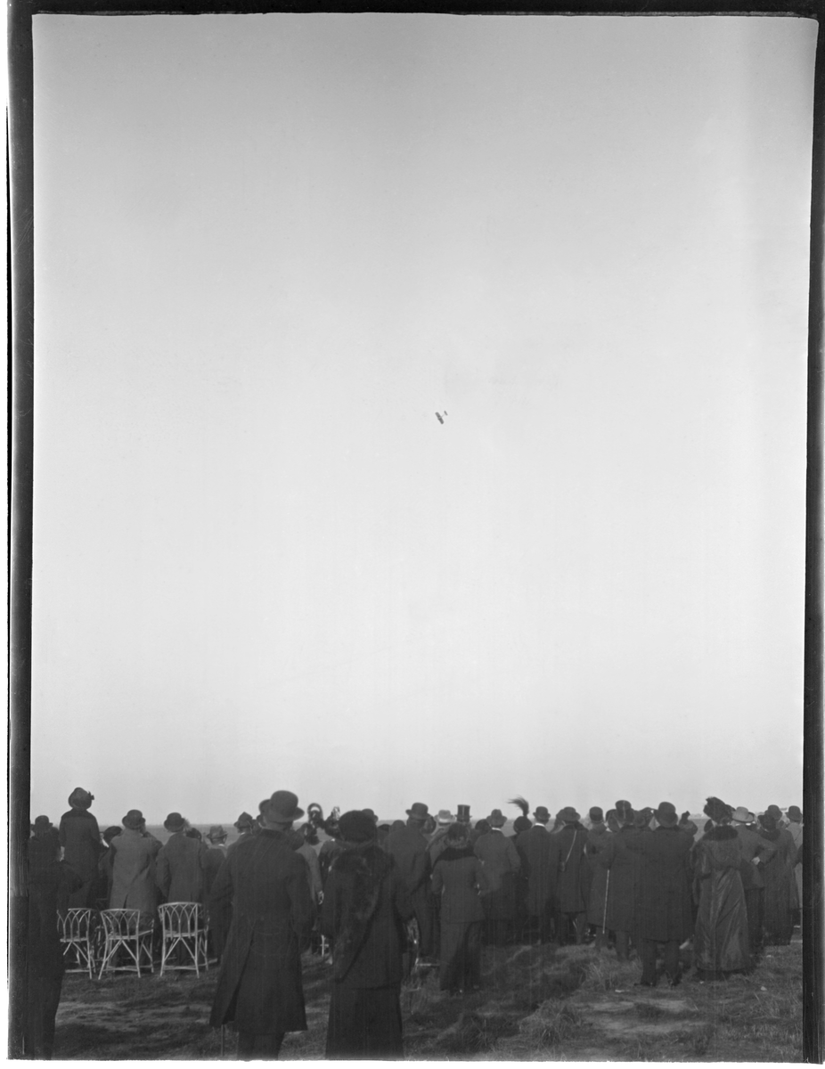 Folksamling vid flygdag i Österrike-Ungern, tidigt 1910-tal. I luften flyger ett monoplan.