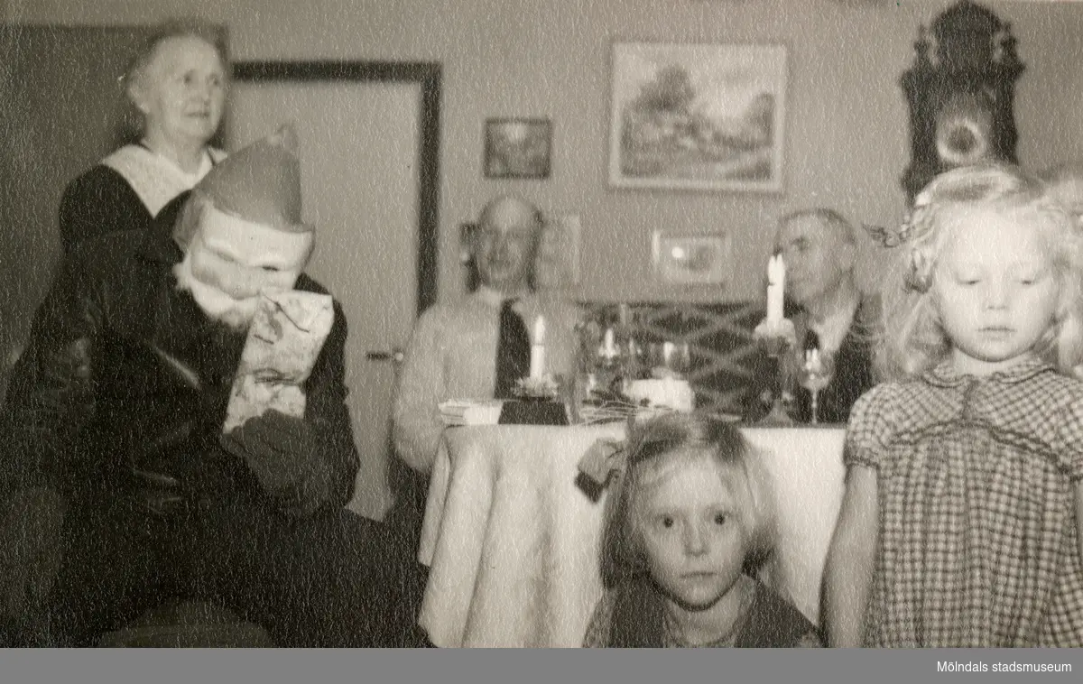 Julafton på övervåningen hemma hos familjen Pettersson, Gamlehagsvägen 17 i Torrekulla år 1950. Från vänster ses Nora Krantz (1879 - 1955), Jultomten?, Karl Holmberg och Carl Krantz (1880 - 1956). I förgrunden ses systrarna Karin Pettersson (född 1947, gift Hansson) och Eva (född 1944, gift Kempe), barnbarn till Nora och Carl.