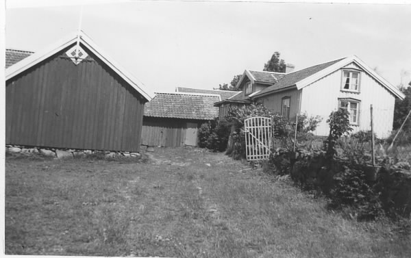 Åkulla gård i Onsala med bostadshus och ekonomibyggnader. Bostadshuset ligger på en något högre marknivå och på stödmuren hägnas tomten av ett trådstaket, där grinden står öppen.