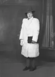 Portrett av kvinne i pels og hatt, helfigur, februar 1943.
B