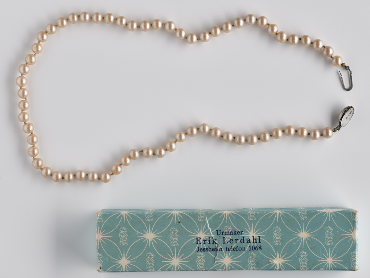 Perlekjede med pappeske i lys turkis farge. 

Diverse smykker som har tilhørt Synnøve Brændshøi. De fleste er nok fra 40- og 50-tallet.