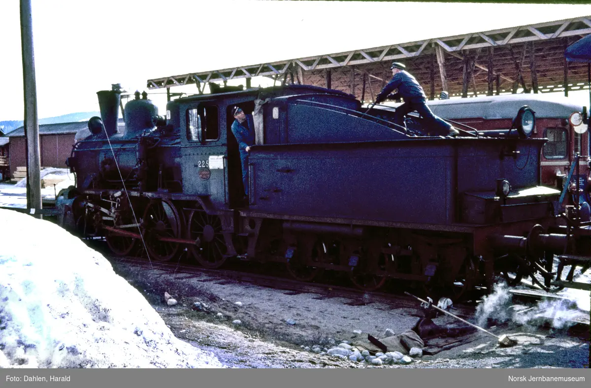 Damplokomotiv type 21b nr. 225 med tog til Kongsberg på Flesberg stasjon. Fyrbøeren skuffer frem kull på tenderen.